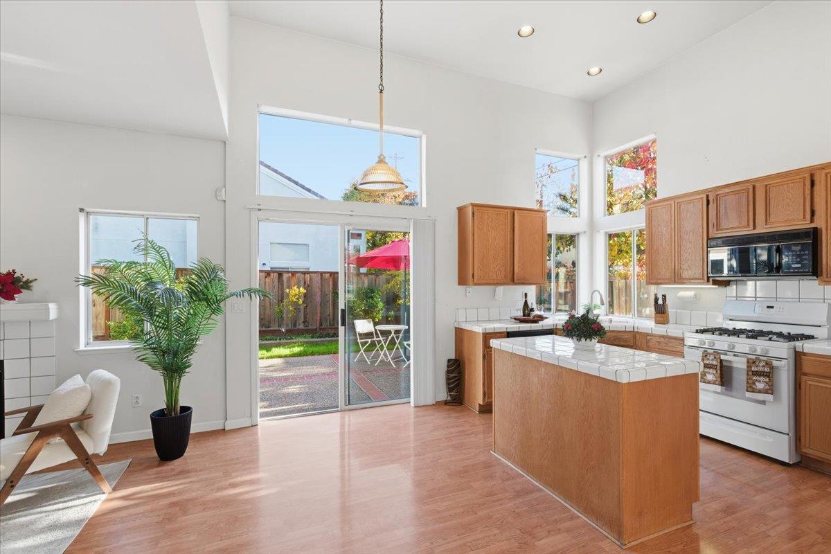 29273 Chance Street Hayward, CA 94544 - Photo 11 of 51 a kitchen with stainless steel appliances granite countertop a stove top oven a sink dishwasher a dining table and chairs with wooden floor