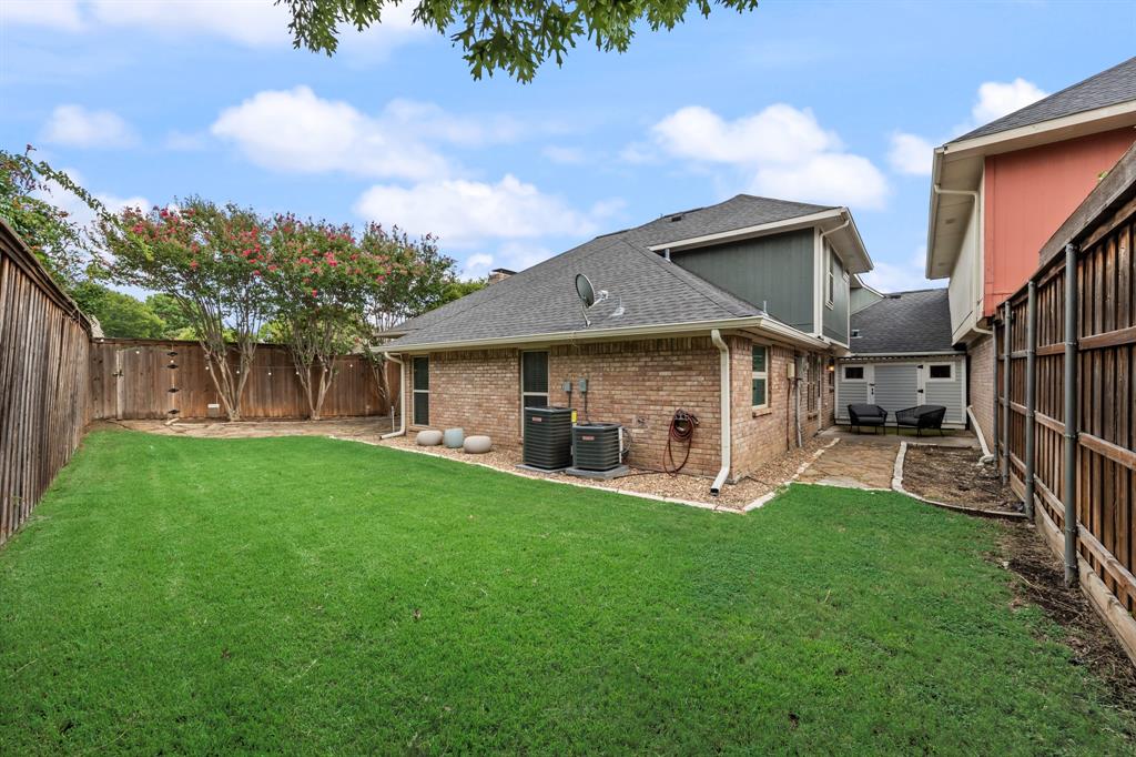 2807 Silverspring Road Carrollton, TX 75006 - Photo 18 of 37 The wood-fenced backyard offers an open lawn framed by mature trees, plus a tucked-away patio.