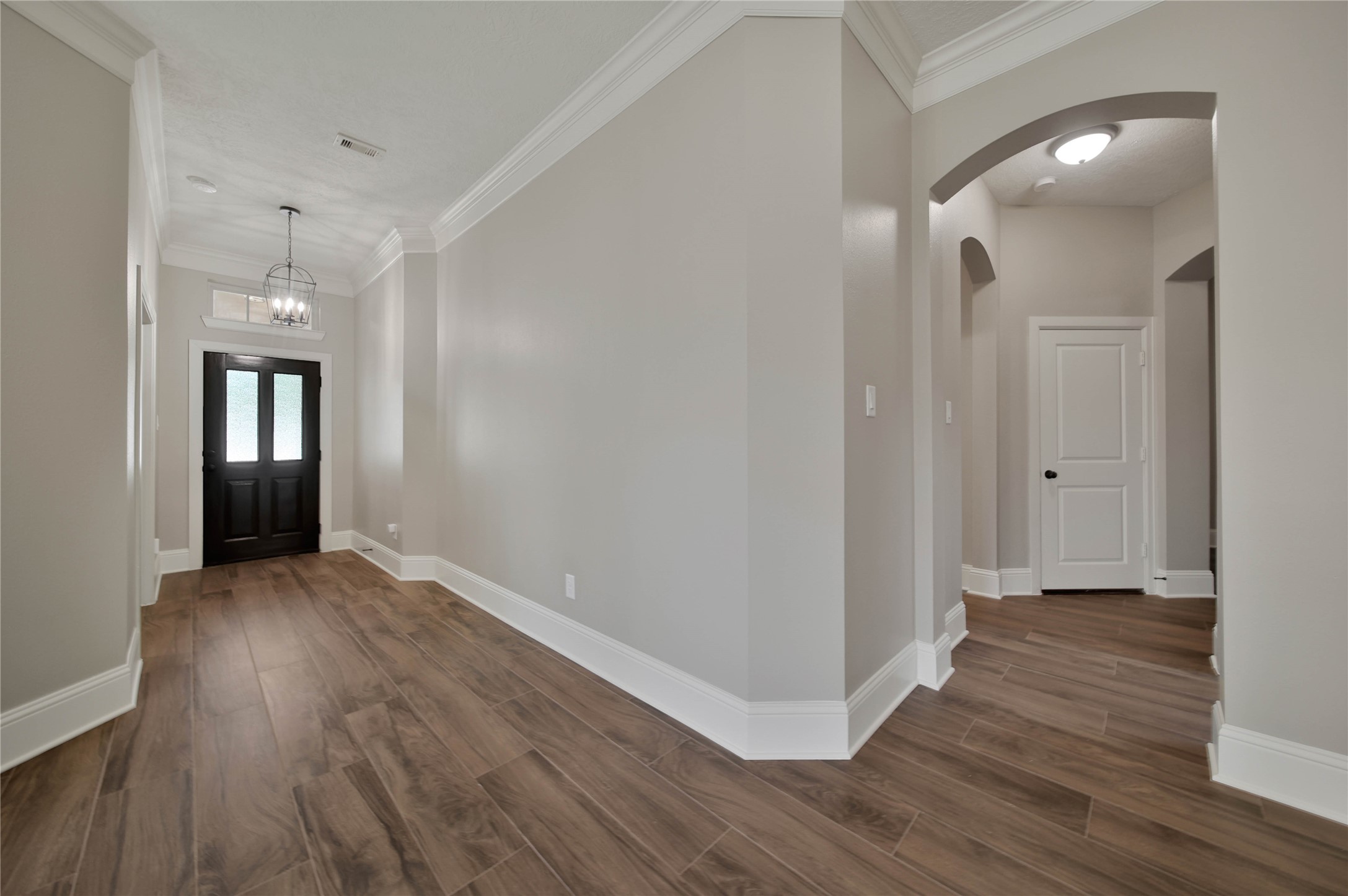 1215 Jake Springs Court Spring, TX 77386 - Photo 3 of 49 Step inside through the wood and glass front door into the elegant entry with double crown molding and wood-look tile floors.