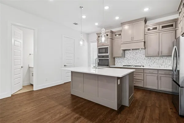 a kitchen with stainless steel appliances granite countertop a sink a stove and a refrigerator