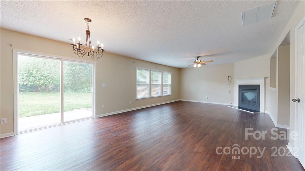 10619 Bedlington Road Charlotte, NC 28278 - Photo 11 of 26 a view of a livingroom with wooden floor a fireplace and windows