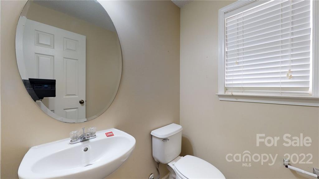 10619 Bedlington Road Charlotte, NC 28278 - Photo 12 of 26 a bathroom with a toilet sink and mirror