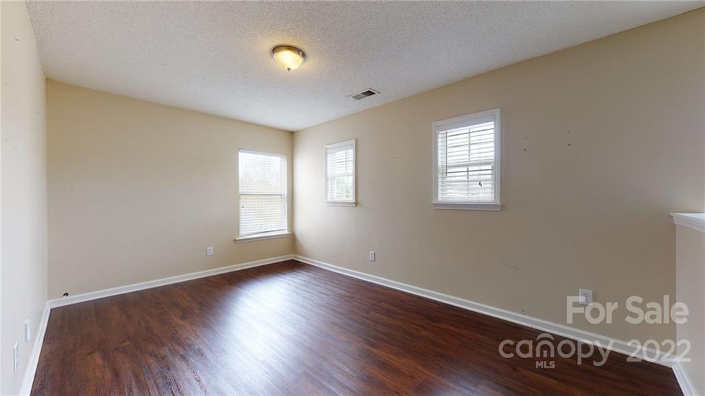 10619 Bedlington Road Charlotte, NC 28278 - Photo 13 of 26 a view of an empty room with wooden floor and a window