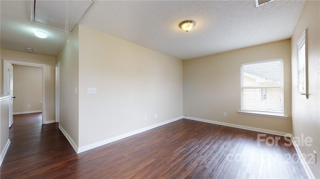 10619 Bedlington Road Charlotte, NC 28278 - Photo 14 of 26 an empty room with wooden floor and windows