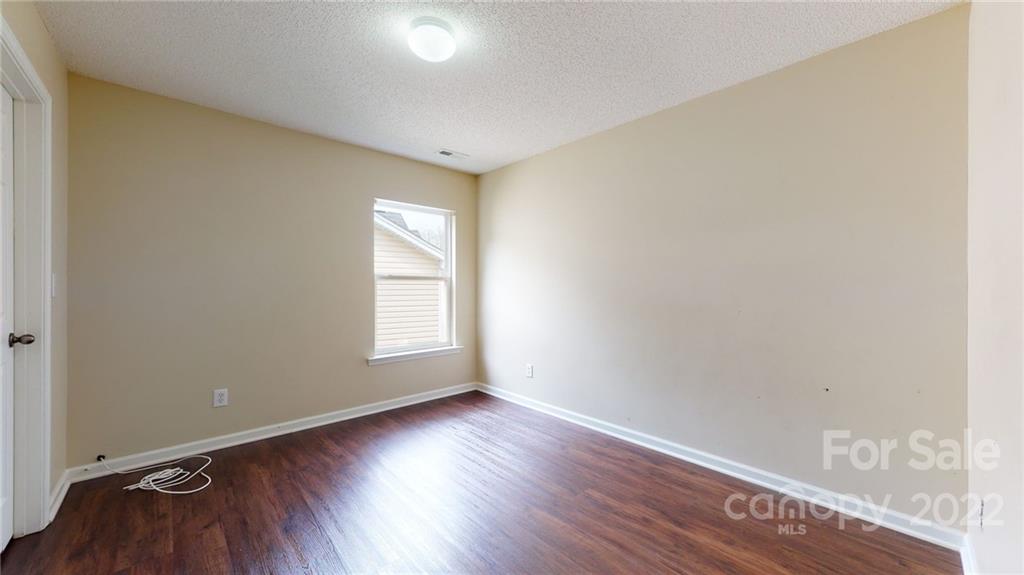 10619 Bedlington Road Charlotte, NC 28278 - Photo 15 of 26 an empty room with wooden floor and windows