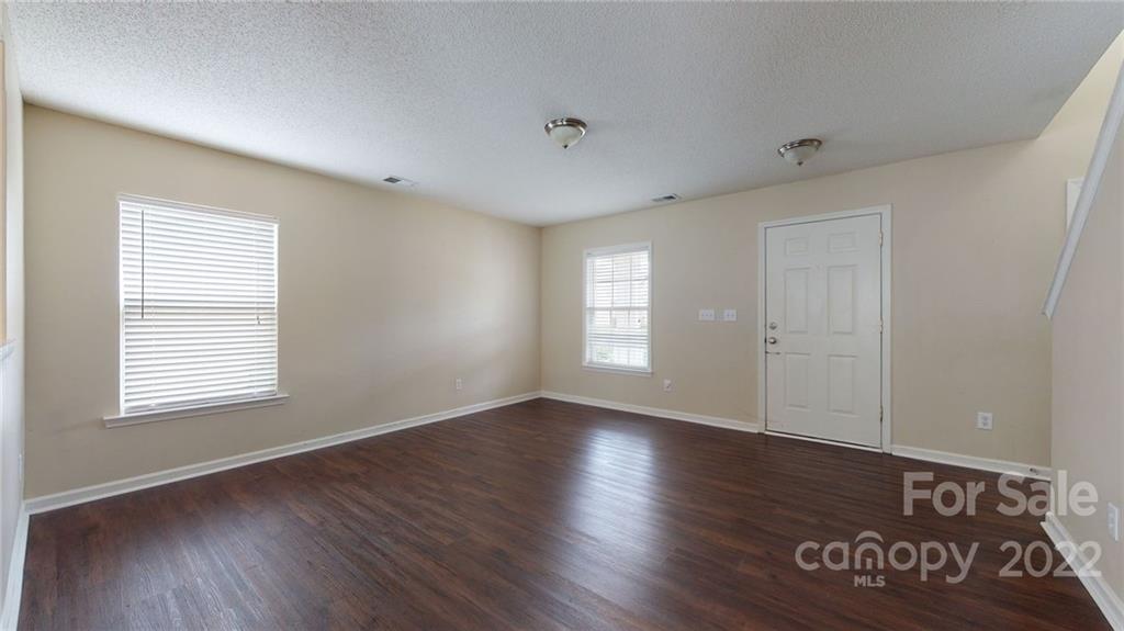 10619 Bedlington Road Charlotte, NC 28278 - Photo 4 of 26 a view of an empty room with wooden floor and a window