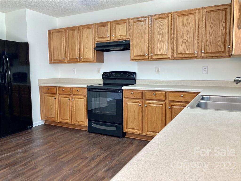 10619 Bedlington Road Charlotte, NC 28278 - Photo 10 of 26 a kitchen with granite countertop wooden cabinets and a sink