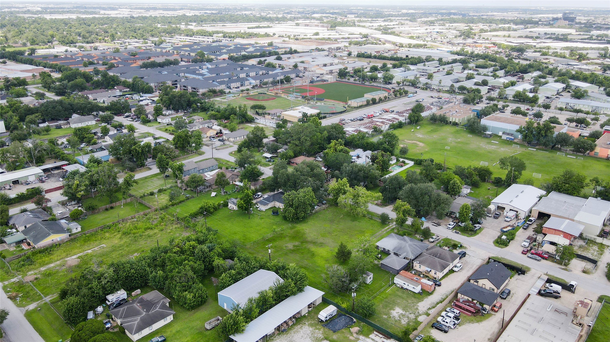 8537 Rannie Road Houston, TX 77080 - Photo 2 of 15 Wide aerial view emphasizing the property’s surrounding context and the value of its large land footprint. The lot sits within a mixed Spring Branch setting near residential pockets, commercial structures, service-oriented properties, parking areas, and major access corridors. This perspective helps buyers visualize the site’s flexibility for future planning, builder use, parking, storage, investment, or development potential.