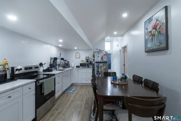 a kitchen with cabinets a sink and chairs