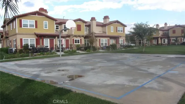 a front view of a brick house with a yard and plants