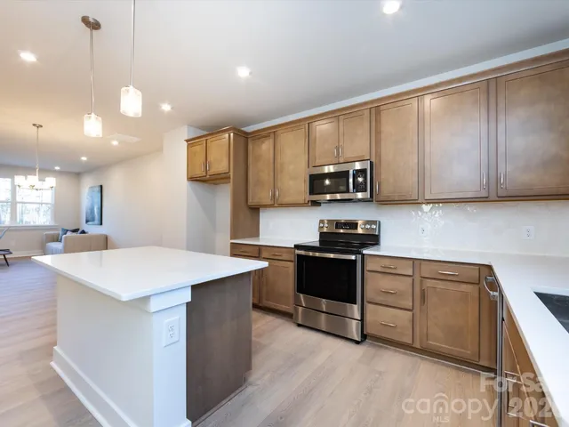 a kitchen with kitchen island granite countertop wooden cabinets and a stove