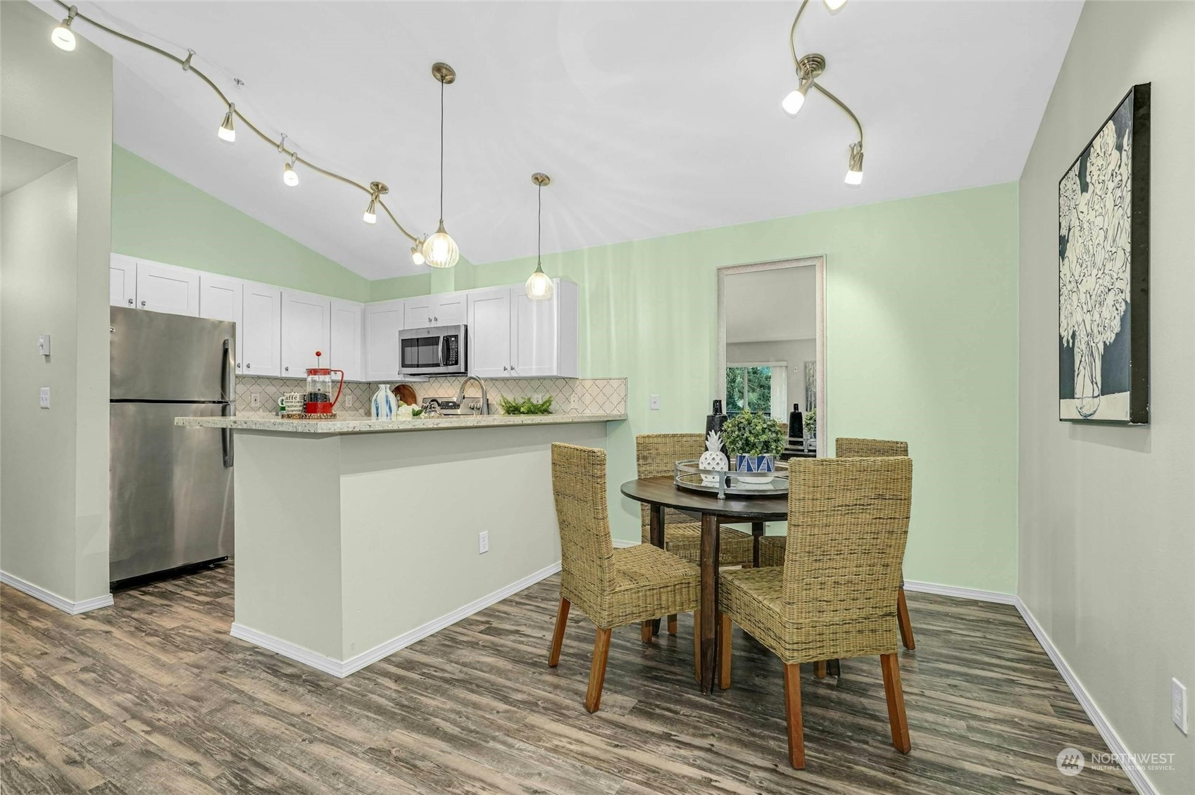 10709 Valley View Road, Unit A303 Bothell, WA 98011 - Photo 7 of 23 a kitchen with stainless steel appliances granite countertop a dining table chairs refrigerator and sink