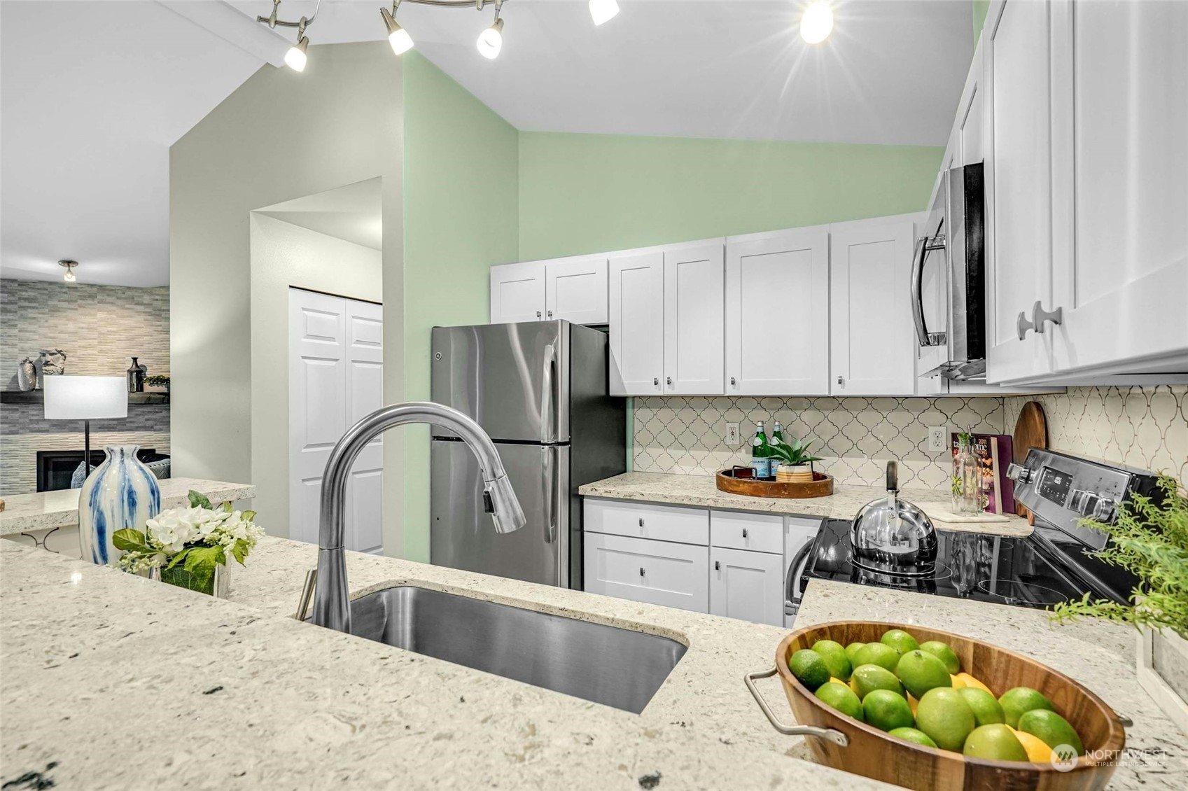 10709 Valley View Road, Unit A303 Bothell, WA 98011 - Photo 8 of 23 a kitchen with stainless steel appliances kitchen island granite countertop a sink and cabinets