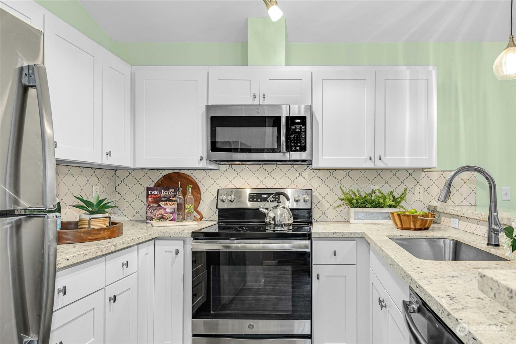 10709 Valley View Road, Unit A303 Bothell, WA 98011 - Photo 9 of 23 a kitchen with stainless steel appliances granite countertop white cabinets a stove a sink and dishwasher