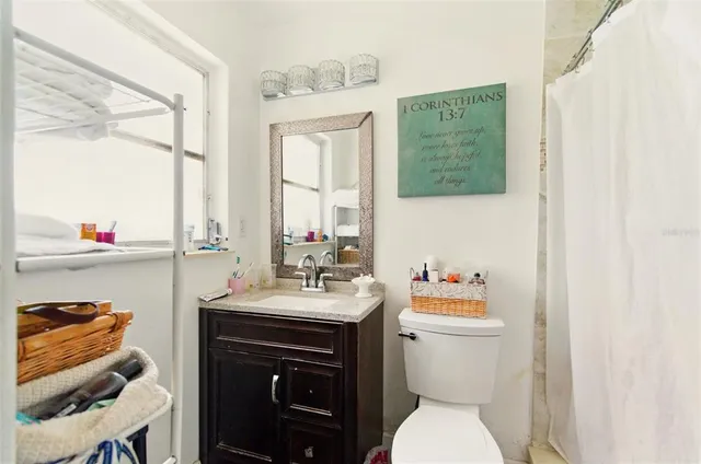 a bathroom with a sink vanity mirror and toilet
