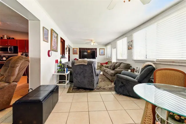 a living room with furniture a flat screen tv and a window