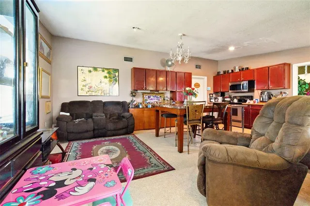 a living room with furniture kitchen view and a large window