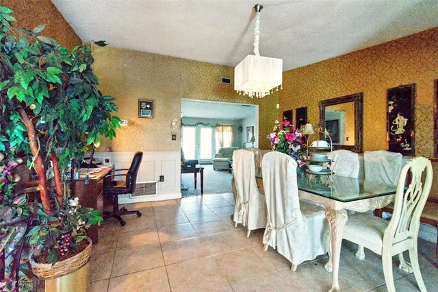 a dining room with furniture a chandelier and window