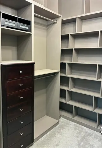 a view of walk in closet with empty racks