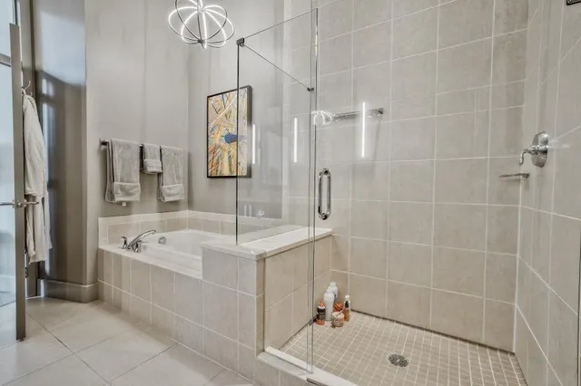 a bathroom with a tub a sink and glass door shower