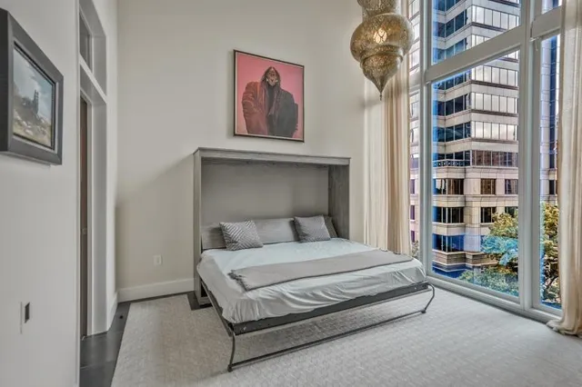 a bedroom with a large bed and a chandelier