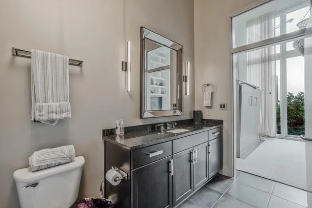 a spacious bathroom with a granite countertop toilet a sink and a mirror