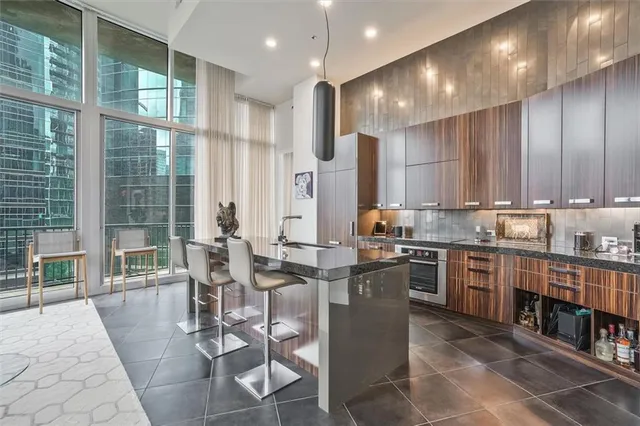 a kitchen with stainless steel appliances granite countertop wooden cabinets a dining table and chairs