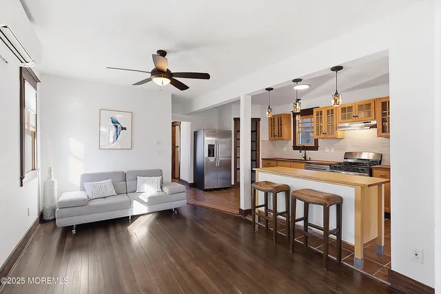 a living room with stainless steel appliances furniture and a kitchen view