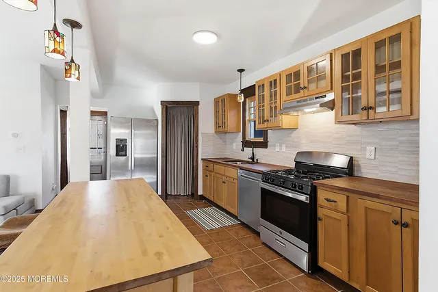 a kitchen with stainless steel appliances granite countertop a stove and a refrigerator