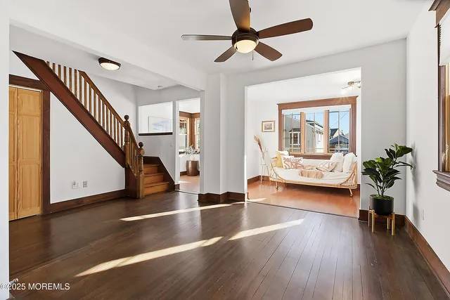 a view of a livingroom with furniture a ceiling fan and wooden floor