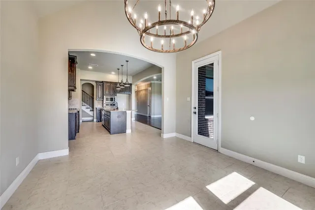 en view of a livingroom with a chandelier furniture and windows