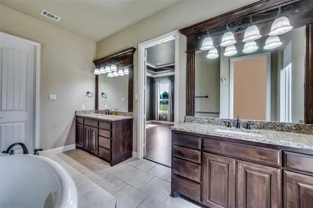 a spacious bathroom with a granite countertop sink and a mirror