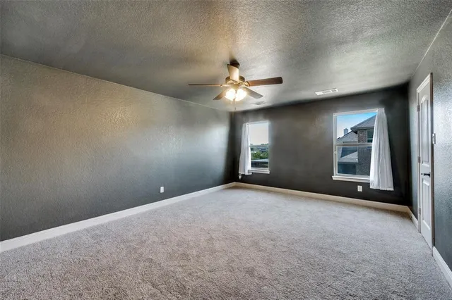 a view of an empty room with a chandelier fan