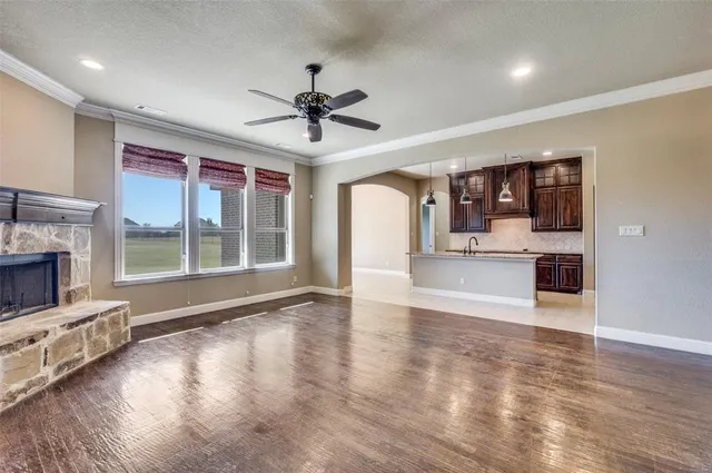 a view of an empty room with a fireplace and a window