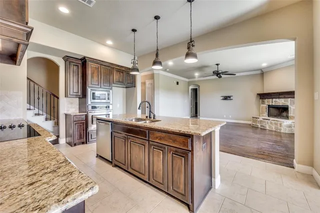 a kitchen with stainless steel appliances granite countertop a sink a oven and a refrigerator