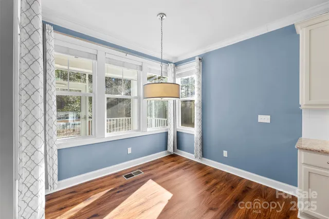 a view of a room with wooden floor and furniture