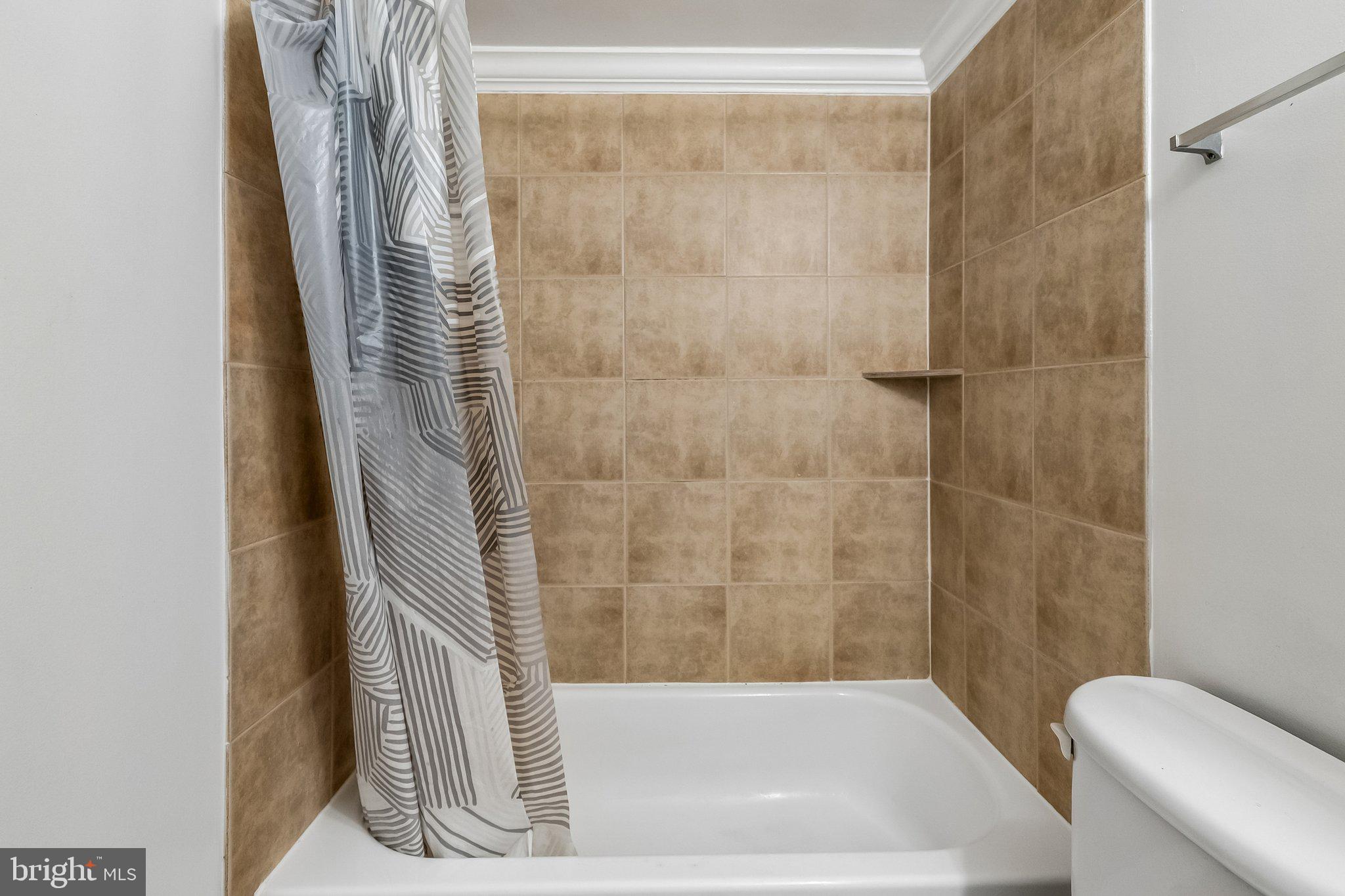 723 Longfellow Street Northwest, Unit 102 Washington, DC 20011 - Photo 11 of 17 a bathroom with a bathtub and shower