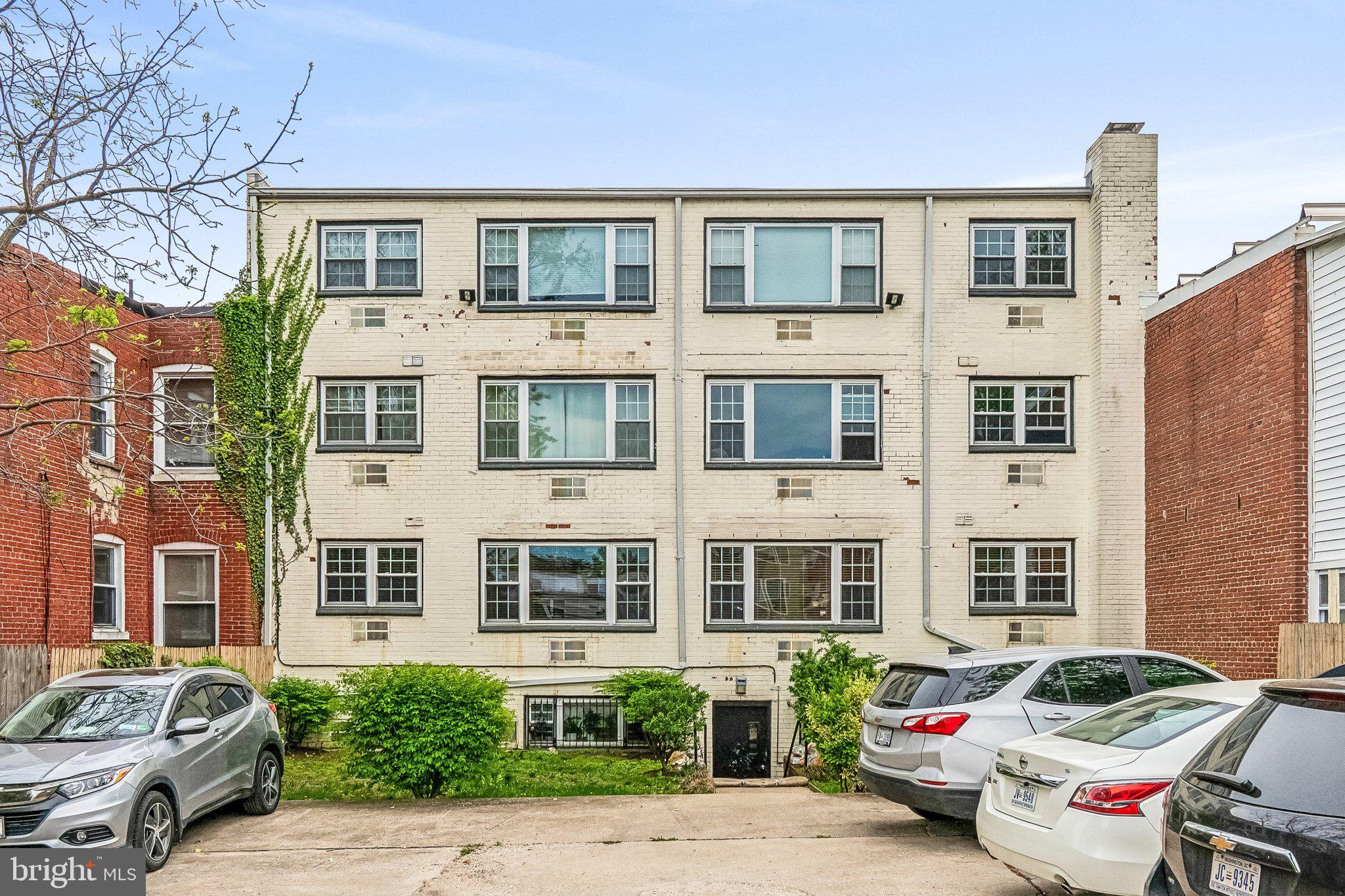 723 Longfellow Street Northwest, Unit 102 Washington, DC 20011 - Photo 17 of 17 a front view of a residential apartment building with a yard