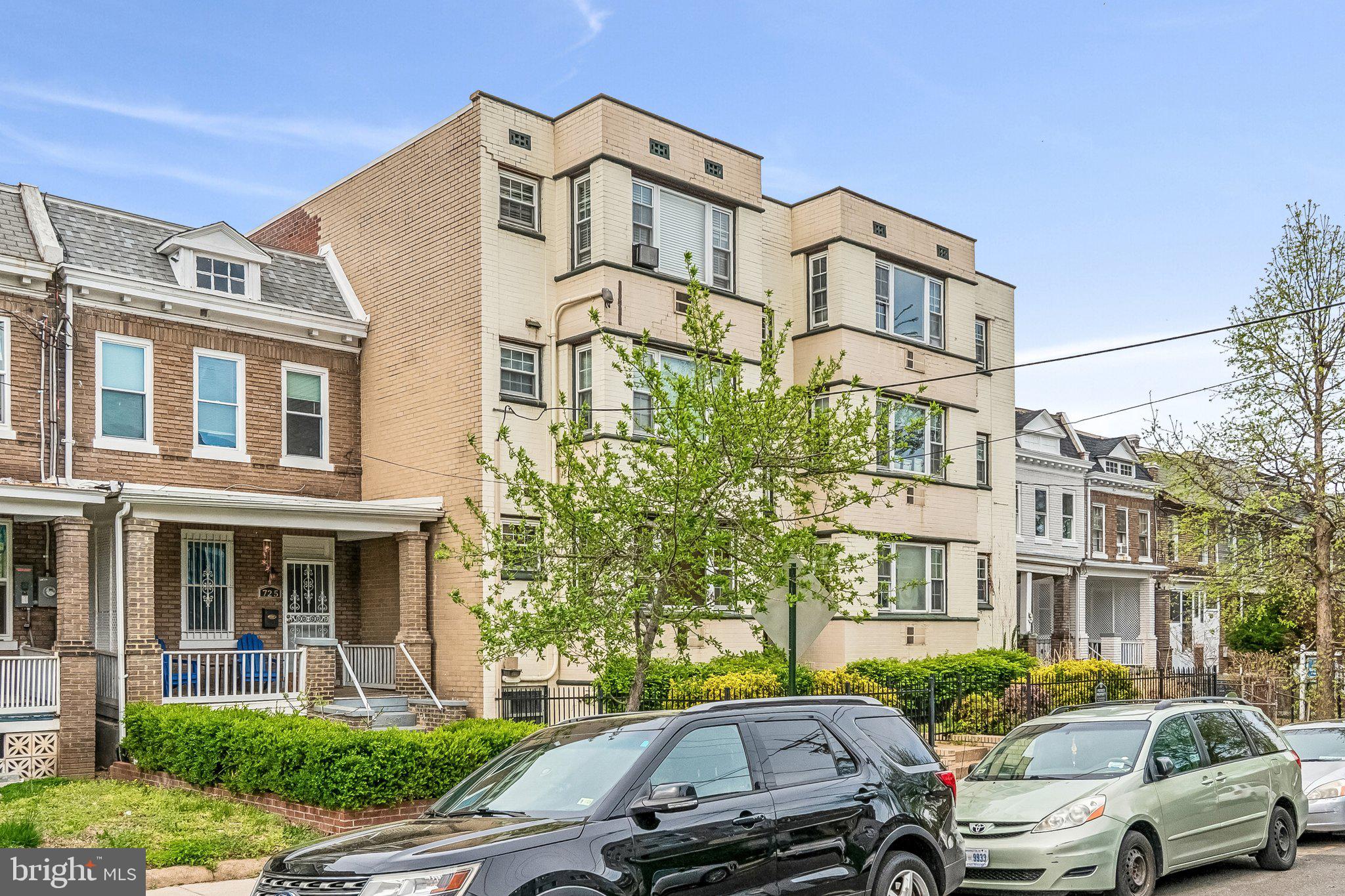 723 Longfellow Street Northwest, Unit 102 Washington, DC 20011 - Photo 3 of 17 a front view of a residential apartment building with a yard