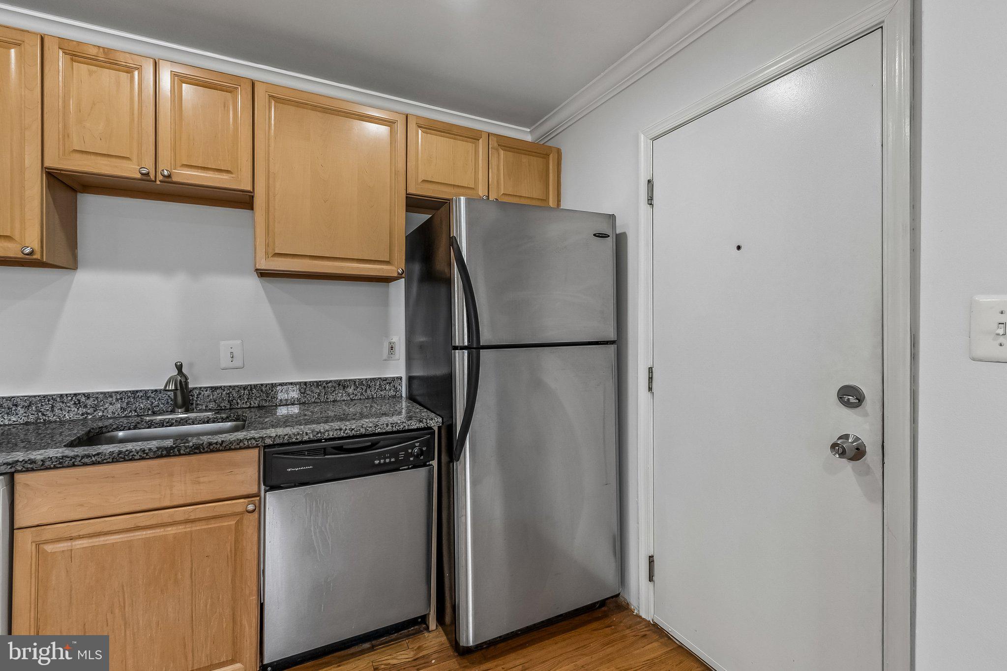 723 Longfellow Street Northwest, Unit 102 Washington, DC 20011 - Photo 5 of 17 a kitchen with stainless steel appliances granite countertop a refrigerator a sink and cabinets