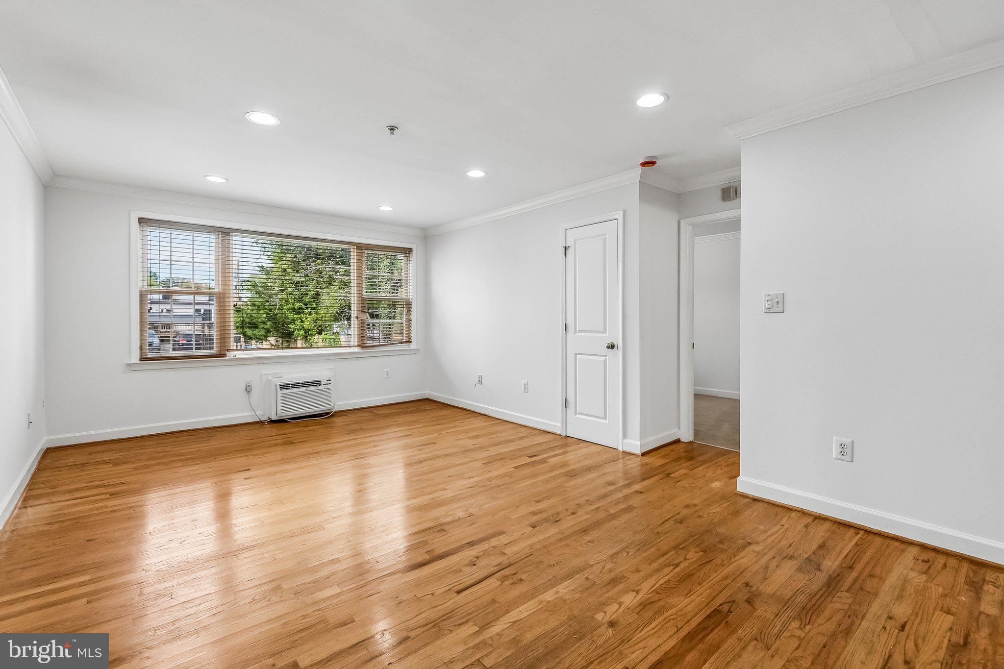 723 Longfellow Street Northwest, Unit 102 Washington, DC 20011 - Photo 6 of 17 a view of empty room with wooden floor and fan