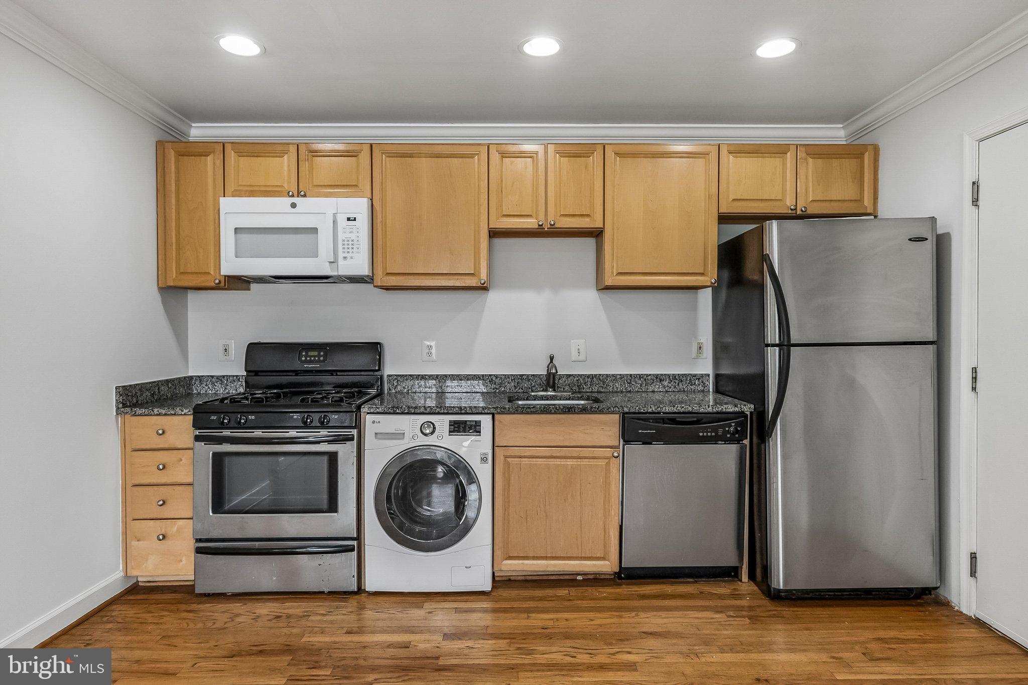 723 Longfellow Street Northwest, Unit 102 Washington, DC 20011 - Photo 7 of 17 a kitchen with stainless steel appliances granite countertop a refrigerator a stove a sink and a microwave