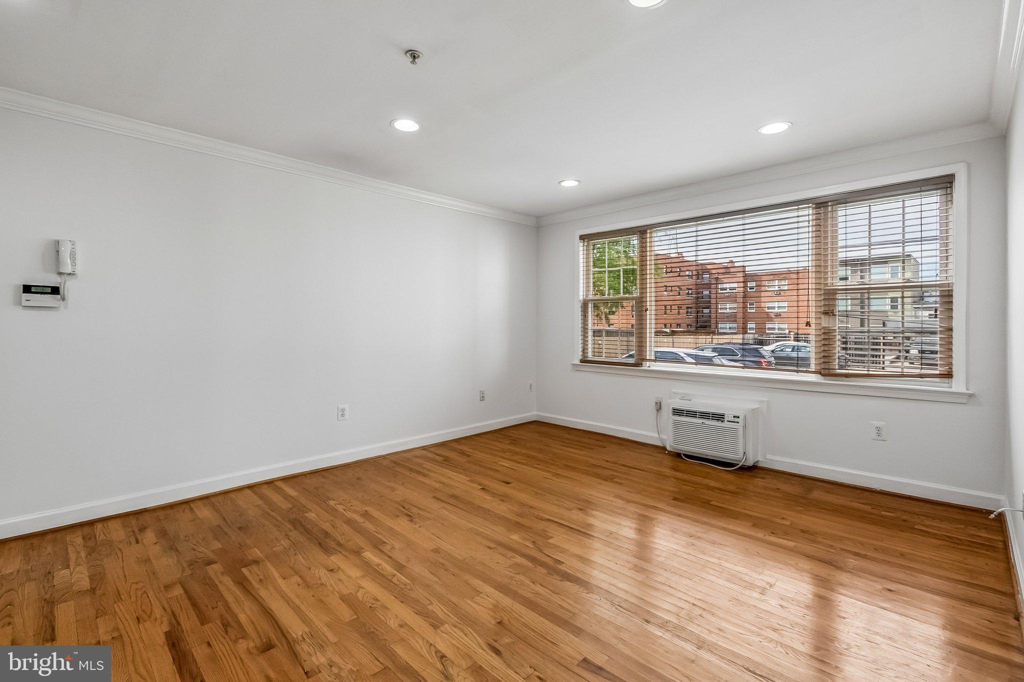 723 Longfellow Street Northwest, Unit 102 Washington, DC 20011 - Photo 9 of 17 wooden floor in an empty room with a window