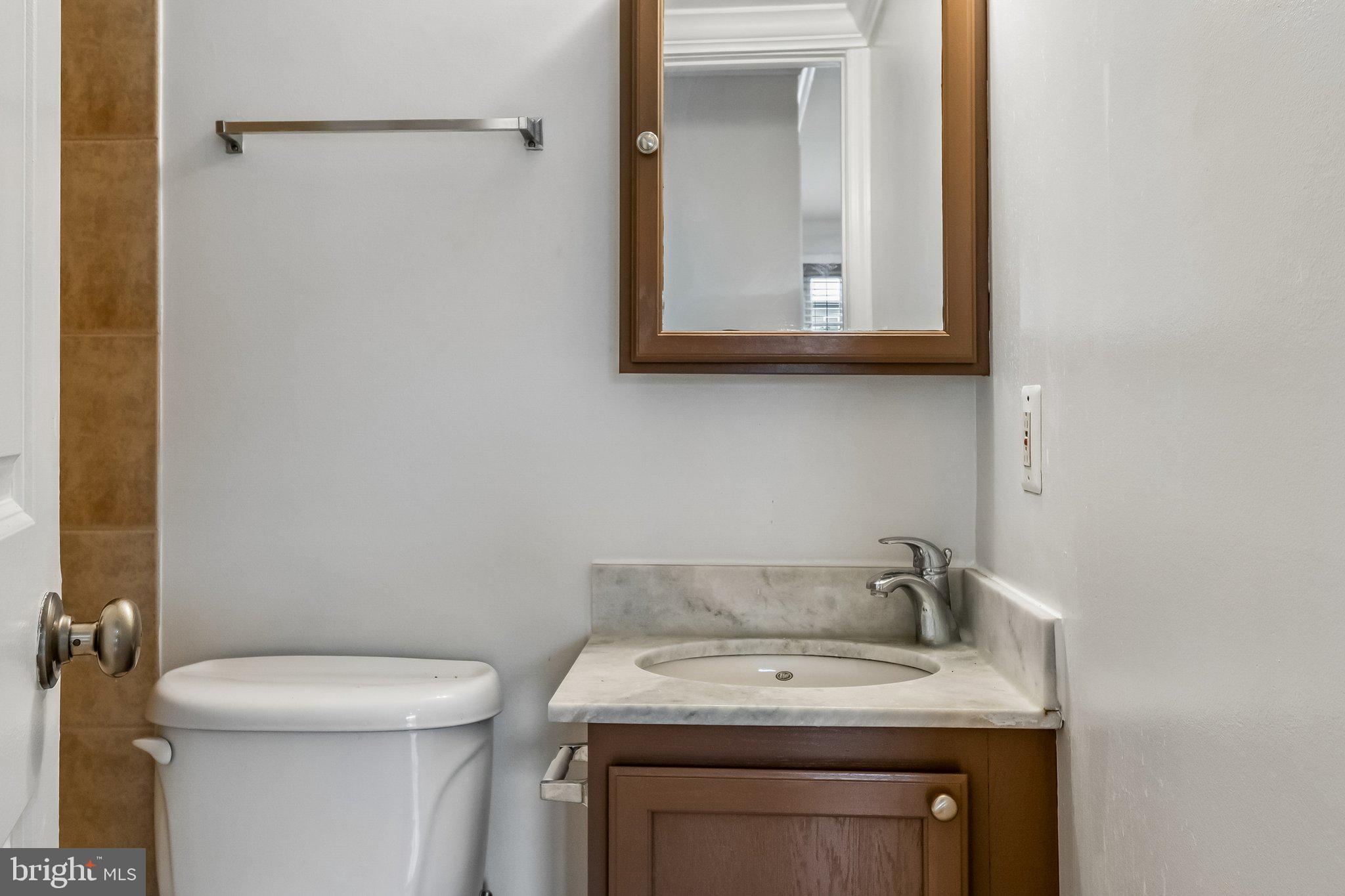 723 Longfellow Street Northwest, Unit 102 Washington, DC 20011 - Photo 10 of 17 a bathroom with a toilet sink and mirror