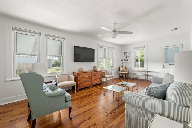 a living room with furniture a flat screen tv and a large window