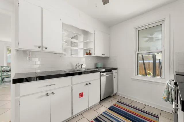 a kitchen with granite countertop white cabinets and white appliances