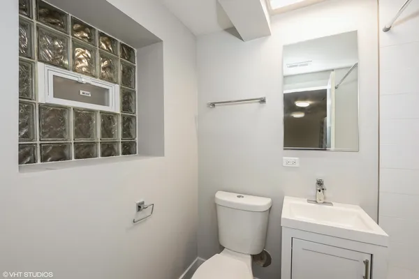 a bathroom with a toilet a sink and mirror