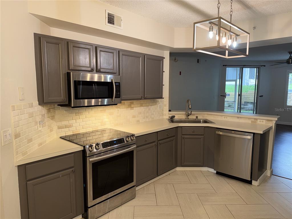 550 Cranes Way, Unit 116 Altamonte Springs, FL 32701 - Photo 5 of 29 a kitchen with granite countertop a stove and a microwave oven