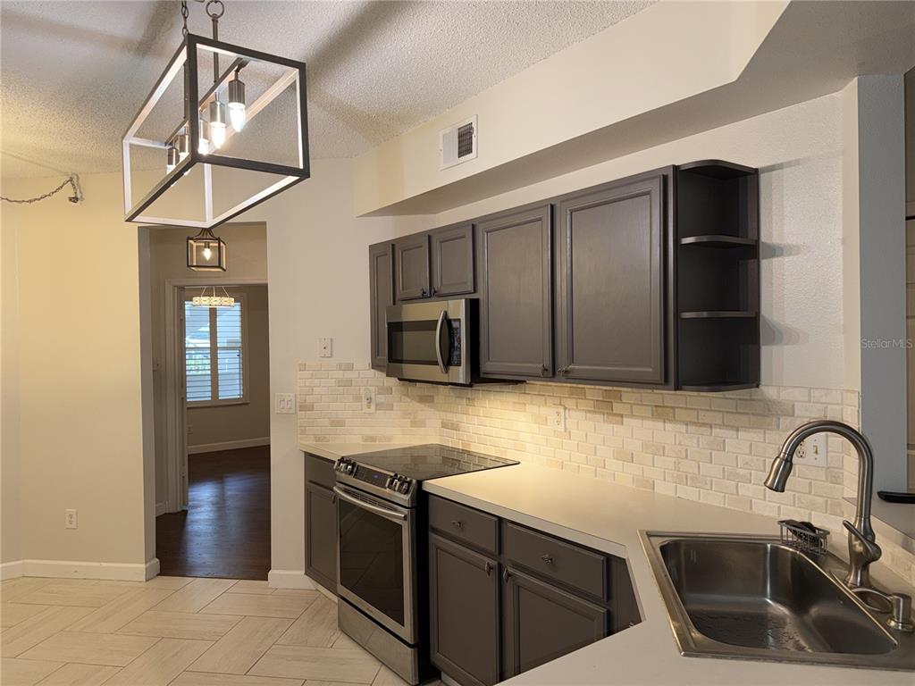 550 Cranes Way, Unit 116 Altamonte Springs, FL 32701 - Photo 8 of 29 a kitchen with kitchen island a counter space a sink and stainless steel appliances