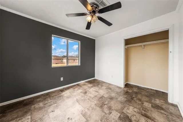 a view of a big room with a ceiling fan and a window
